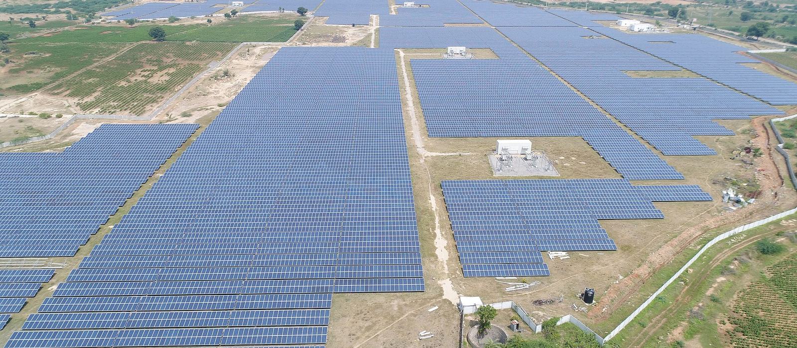 Rows of solar panels on mounting structures at a large Indian solar plant