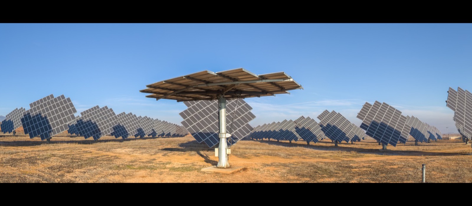 A field of solar trackers turning their panels to follow the sun